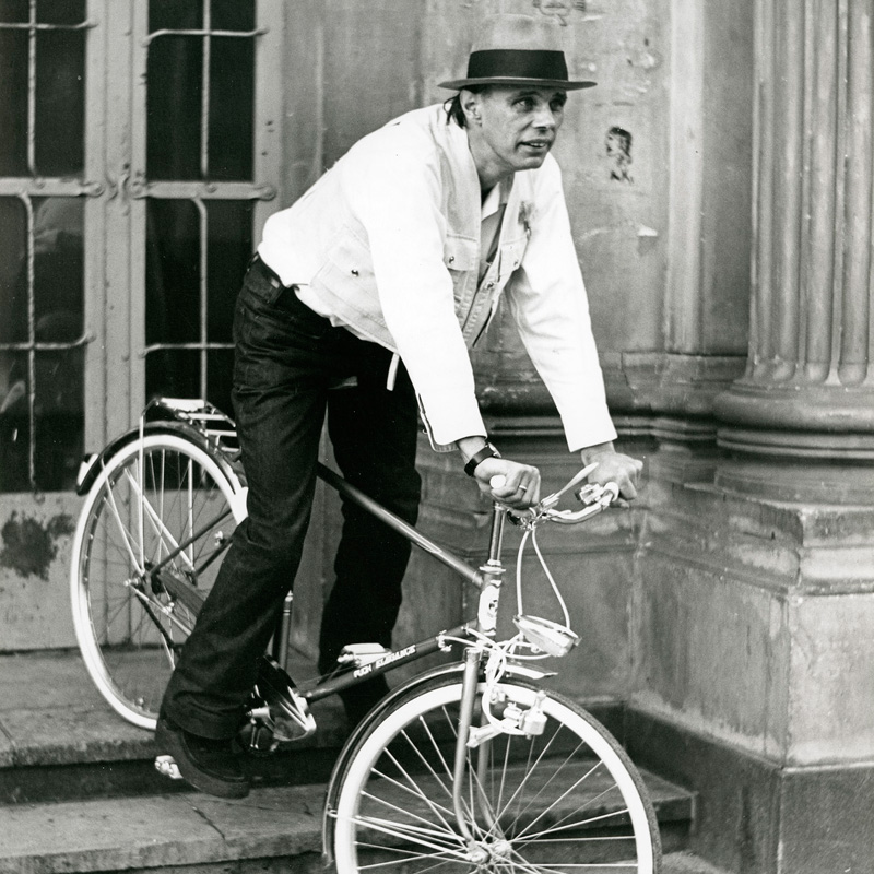 Joseph Beuys mit Fahrrad auf den Stufen der Kunstakademie Düsseldorf. Foto: Hans Lachmann